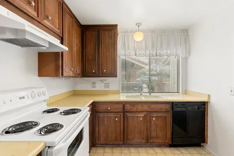 a kitchen with a sink a stove and cabinets