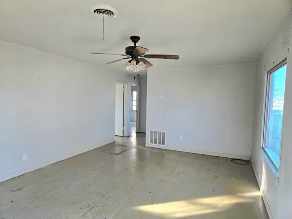 a view of an empty room with a chandelier fan