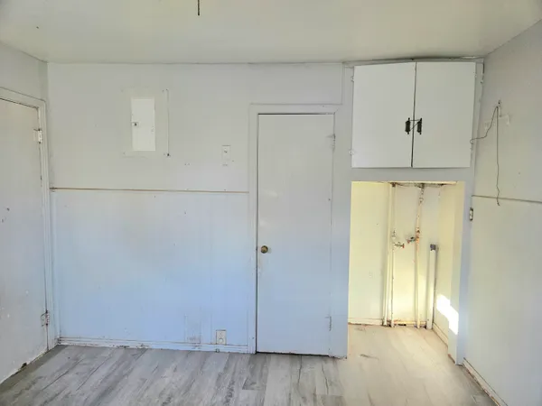 an empty room with wooden floor and mirror