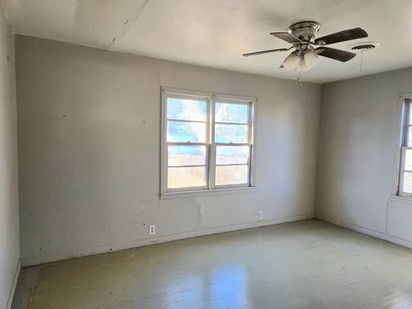 an empty room with a window and a ceiling fan
