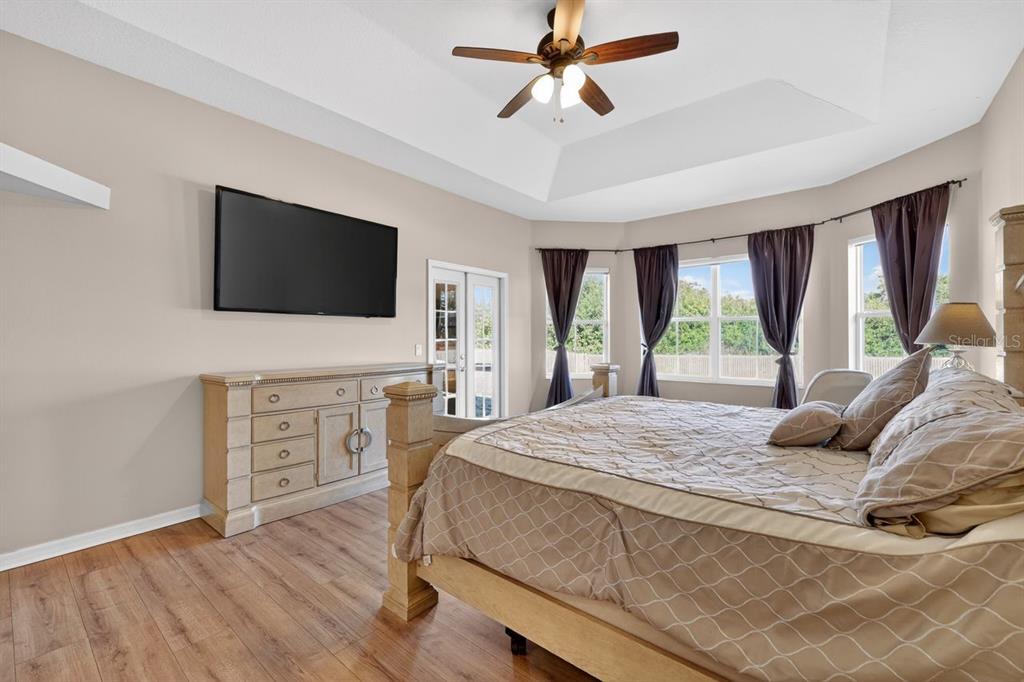 17312 Howling Wolf Run Parrish, FL 34219 - Photo 20 of 41 a bedroom with a bed and a flat screen tv