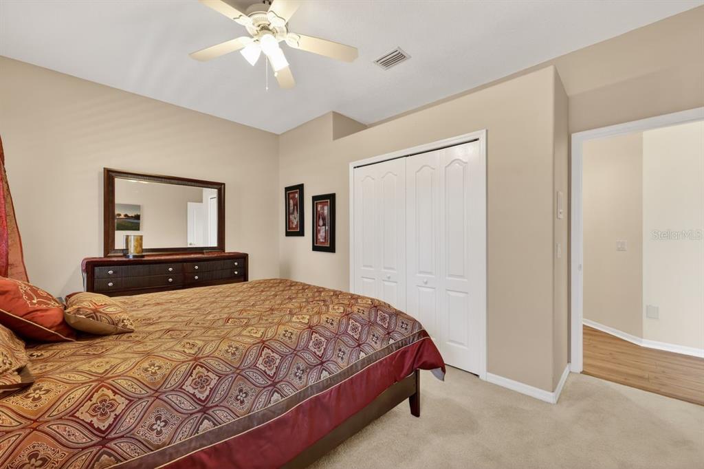 17312 Howling Wolf Run Parrish, FL 34219 - Photo 33 of 41 a bedroom with a large bed and a chandelier