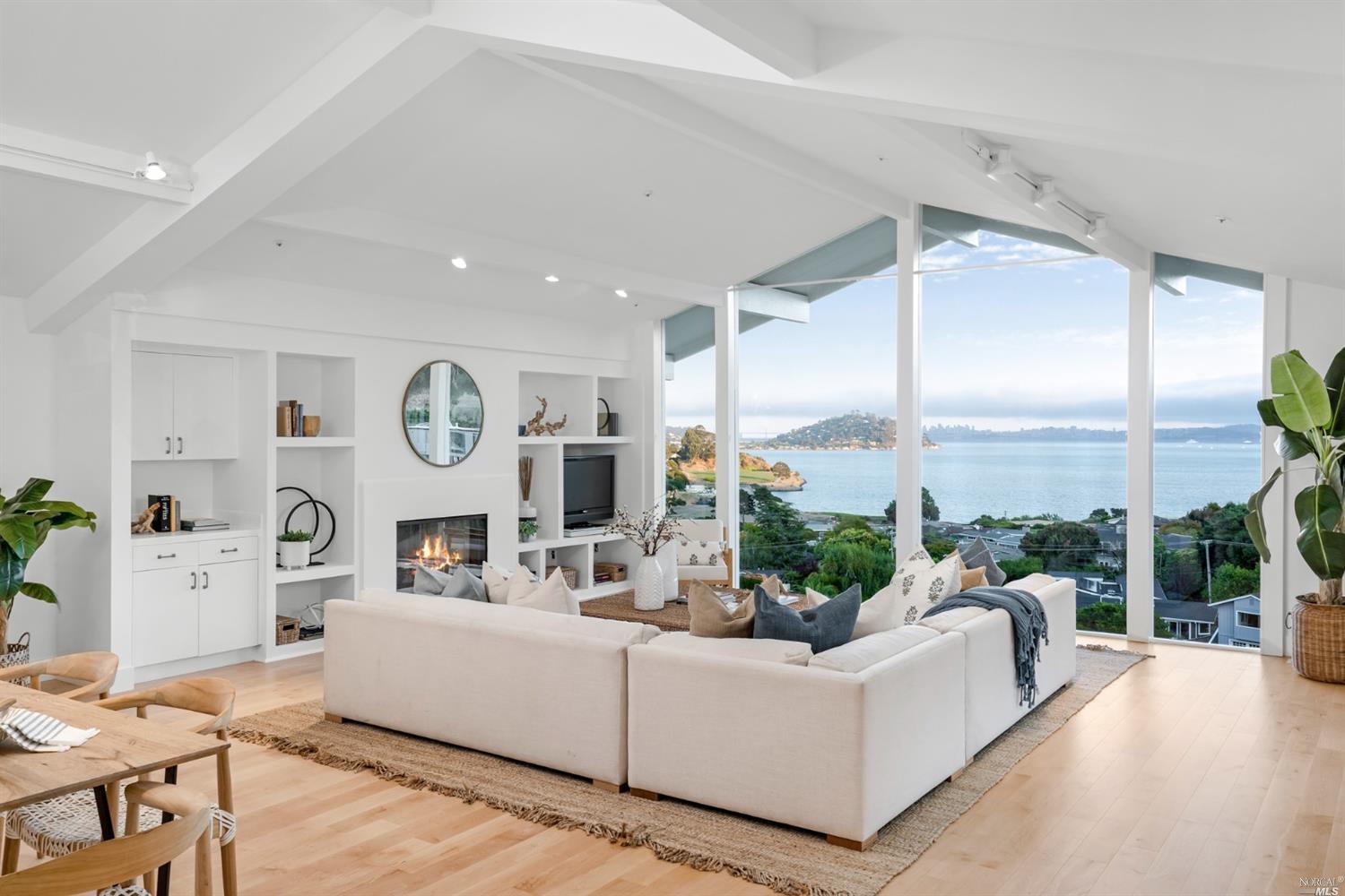 a living room with furniture kitchen view and a large window