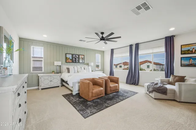 a spacious bedroom with a bed couch chandelier and a window