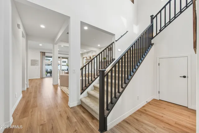 a view of a hallway with wooden floor and staircase