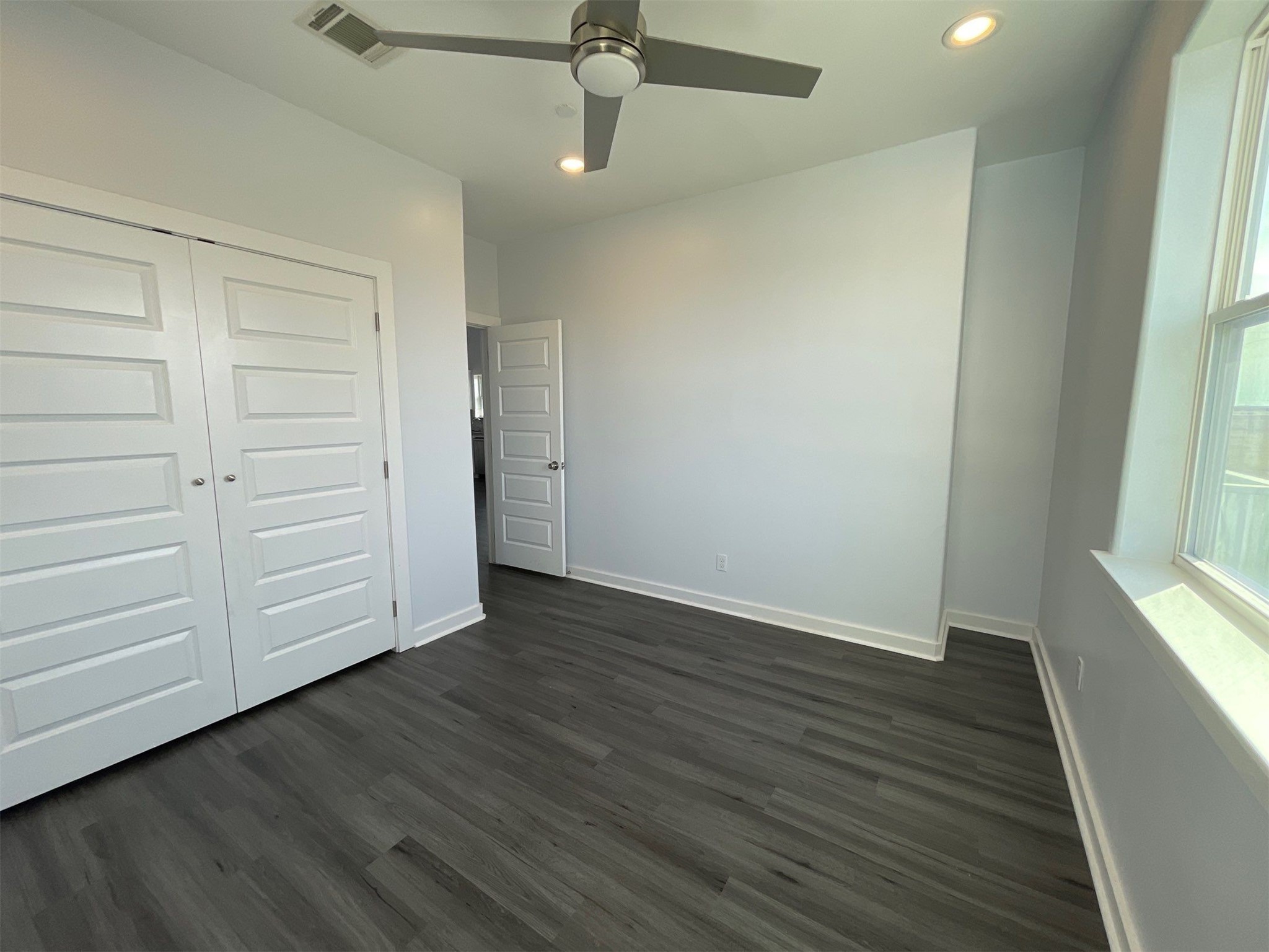 430 Schmidt Road, Unit A2 Sealy, TX 77474 - Photo 3 of 16 an empty room with wooden floor closet and windows