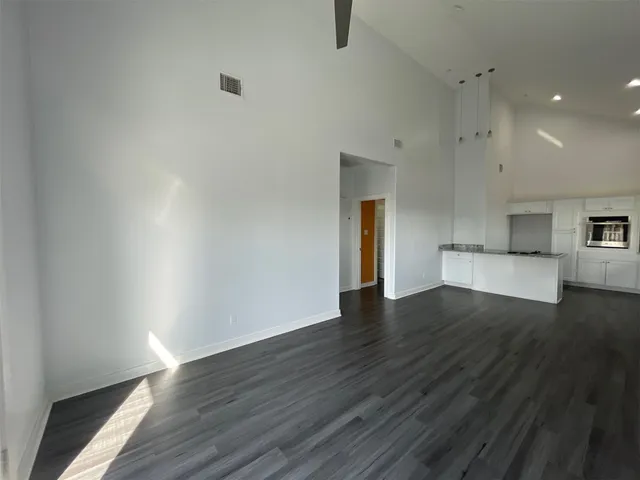 a view of empty room with wooden floor