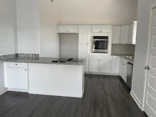 a kitchen with stainless steel appliances granite countertop a stove a sink and a microwave