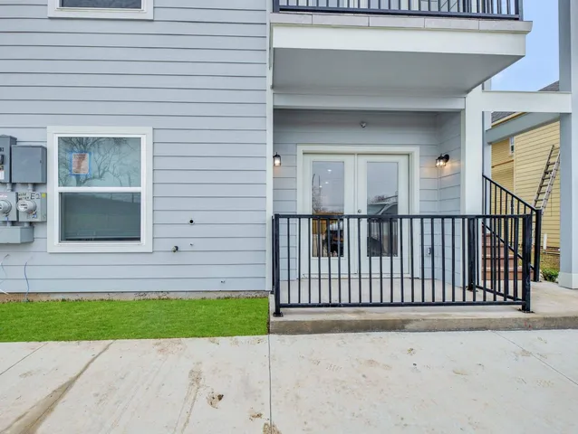 a view of a house with a small yard and wooden fence