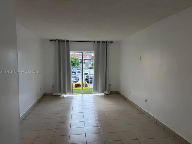 an empty room with floor to ceiling window and an outdoor space