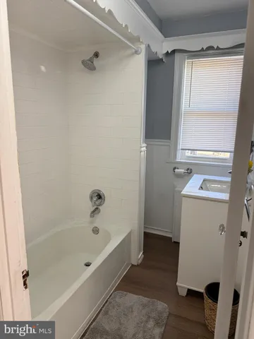 a bathroom with a tub shower and a sink