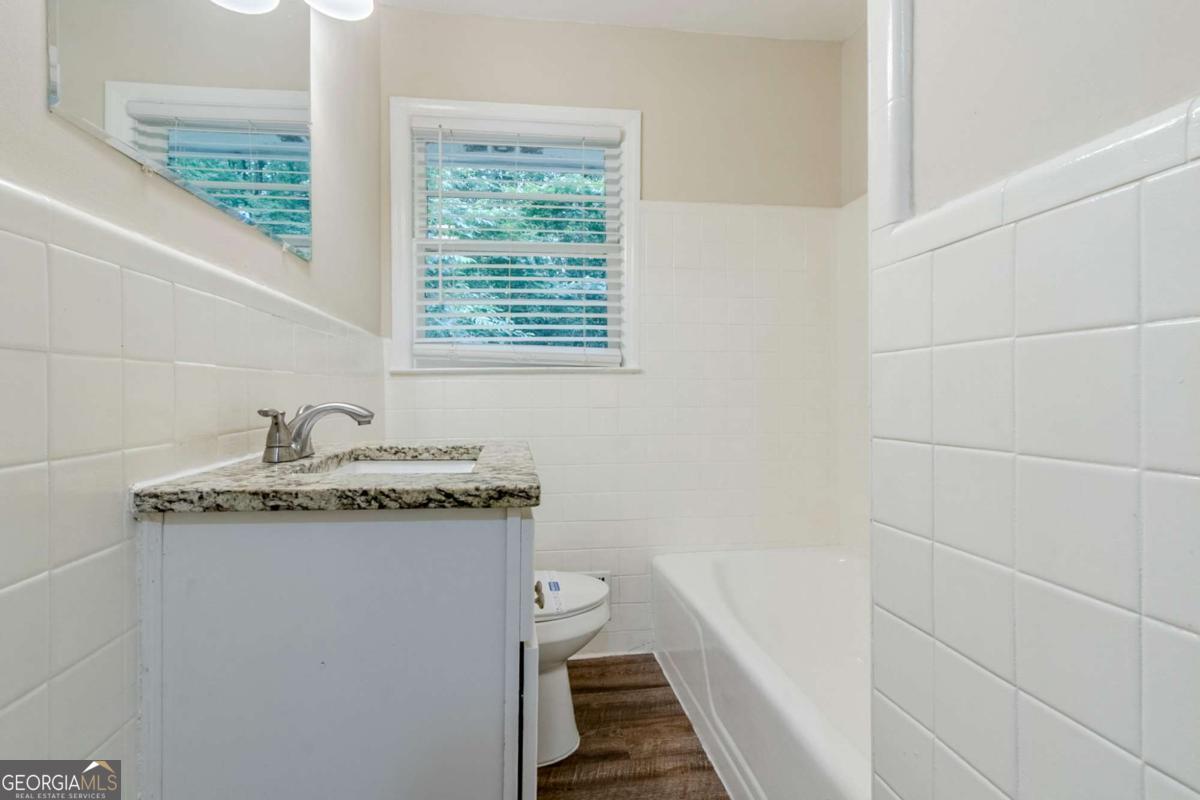 1715 Lee Street Decatur, GA 30035 - Photo 18 of 25 a bathroom with a granite countertop sink a toilet and shower