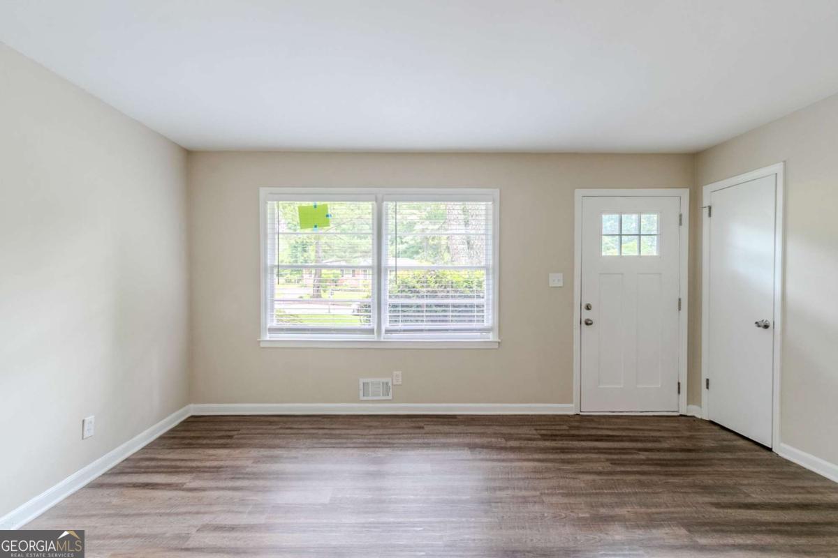 1715 Lee Street Decatur, GA 30035 - Photo 5 of 25 a view of an empty room with wooden floor and a window