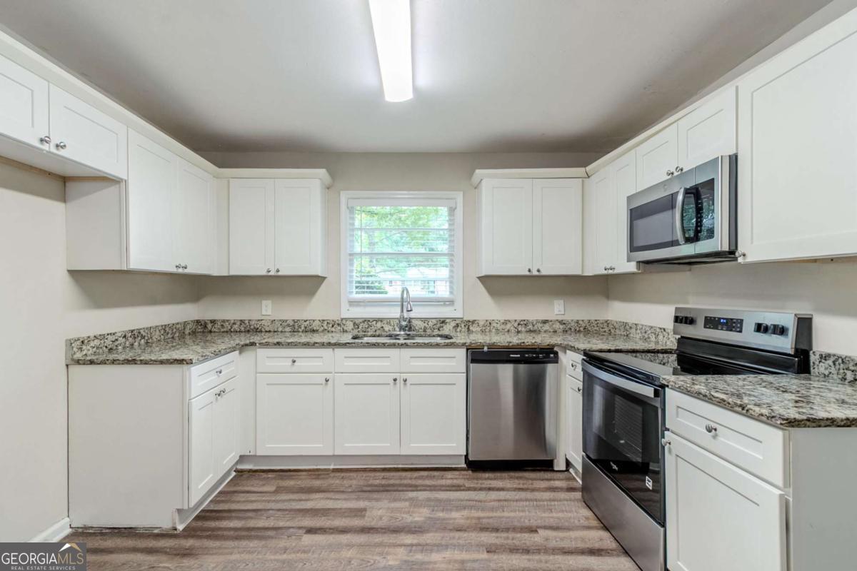 1715 Lee Street Decatur, GA 30035 - Photo 6 of 25 a kitchen with stainless steel appliances granite countertop a stove and a sink