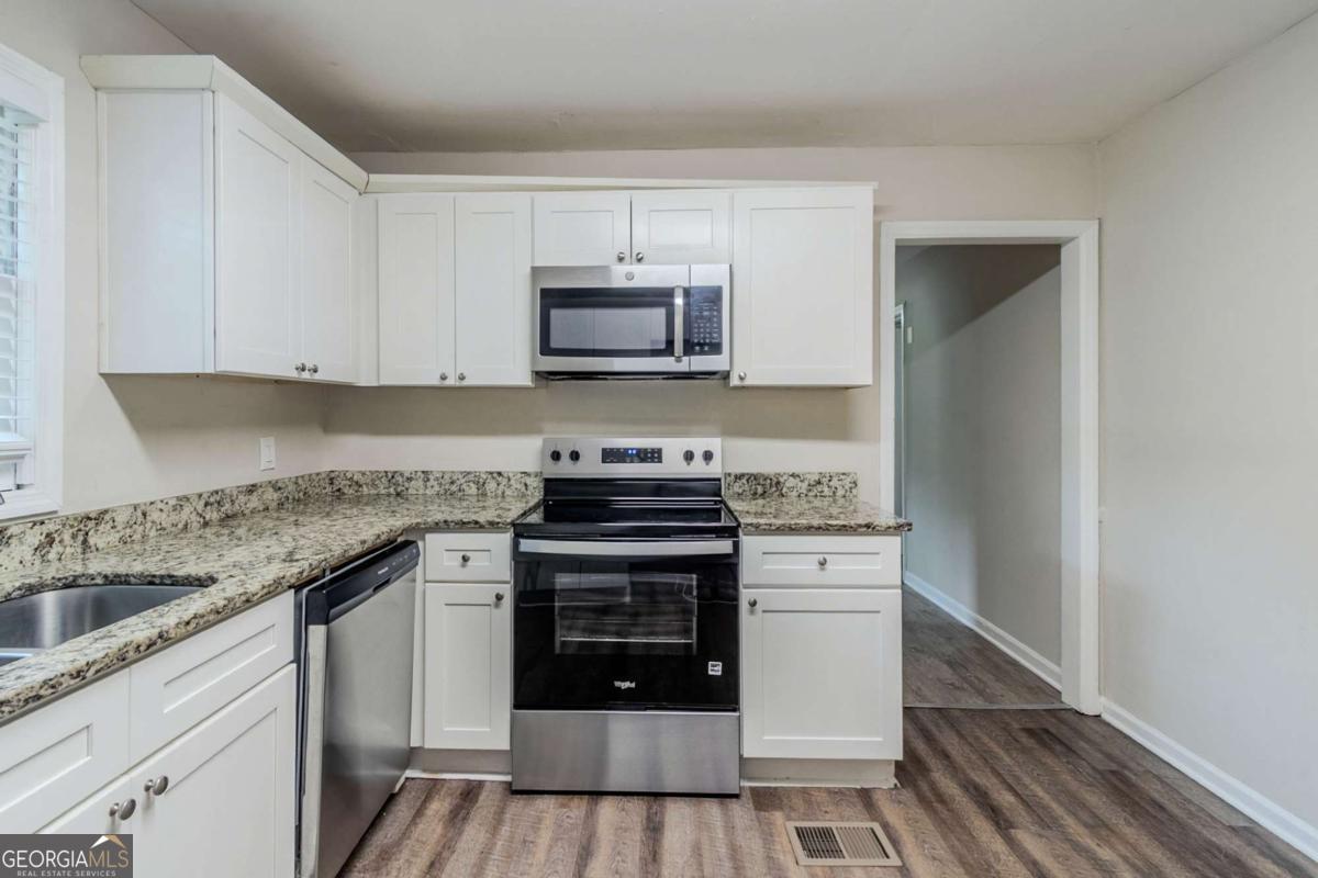 1715 Lee Street Decatur, GA 30035 - Photo 7 of 25 a kitchen with stainless steel appliances granite countertop a stove and a sink