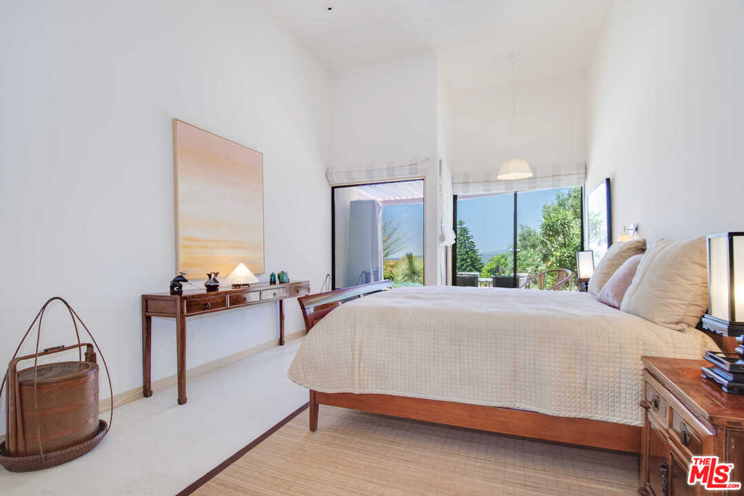 350 Ortega Ridge Road Montecito, CA 93108 - Photo 25 of 39 a bed sitting in a bedroom next to a window with lamp