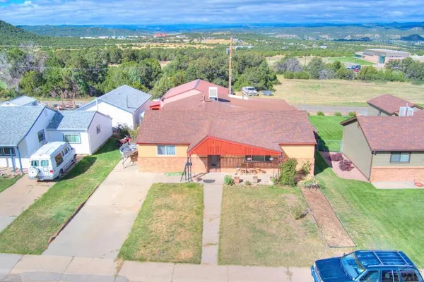 an aerial view of a house with a garden and lake view