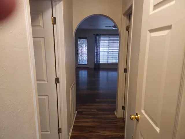 a view of a hallway with wooden floor and entryway