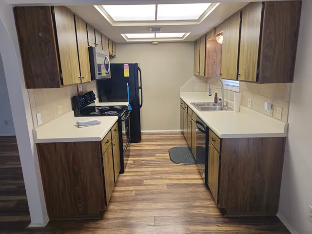a kitchen with a sink appliances and cabinets