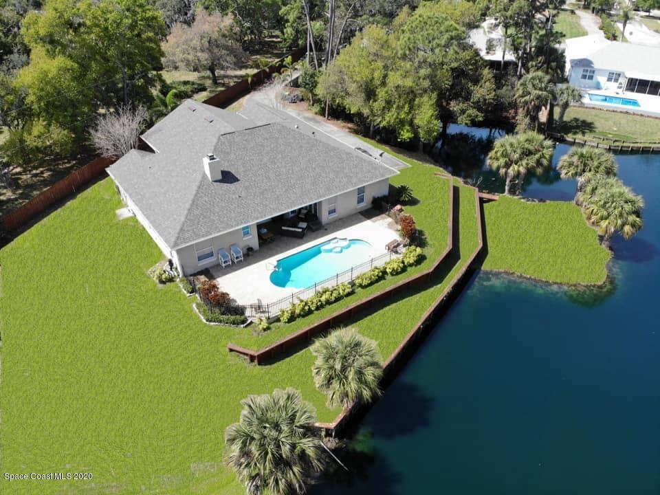 3960 Crooked Mile Road Merritt Island, FL 32952 - Photo 1 of 42 an aerial view of a house with a garden and swimming pool