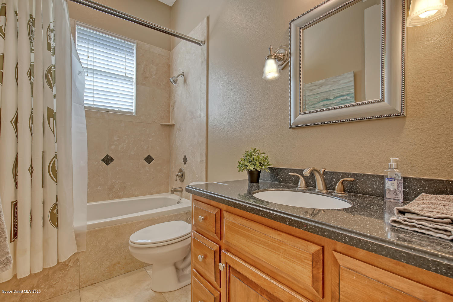 3960 Crooked Mile Road Merritt Island, FL 32952 - Photo 20 of 42 a bathroom with a granite countertop sink toilet a mirror and shower