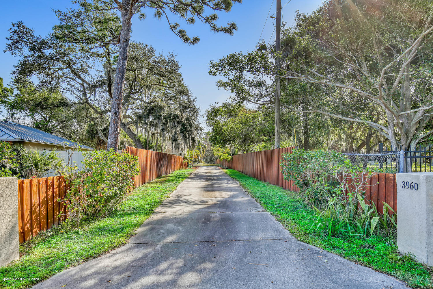 3960 Crooked Mile Road Merritt Island, FL 32952 - Photo 3 of 42 a view of a pathway of flower plants with wooden fence