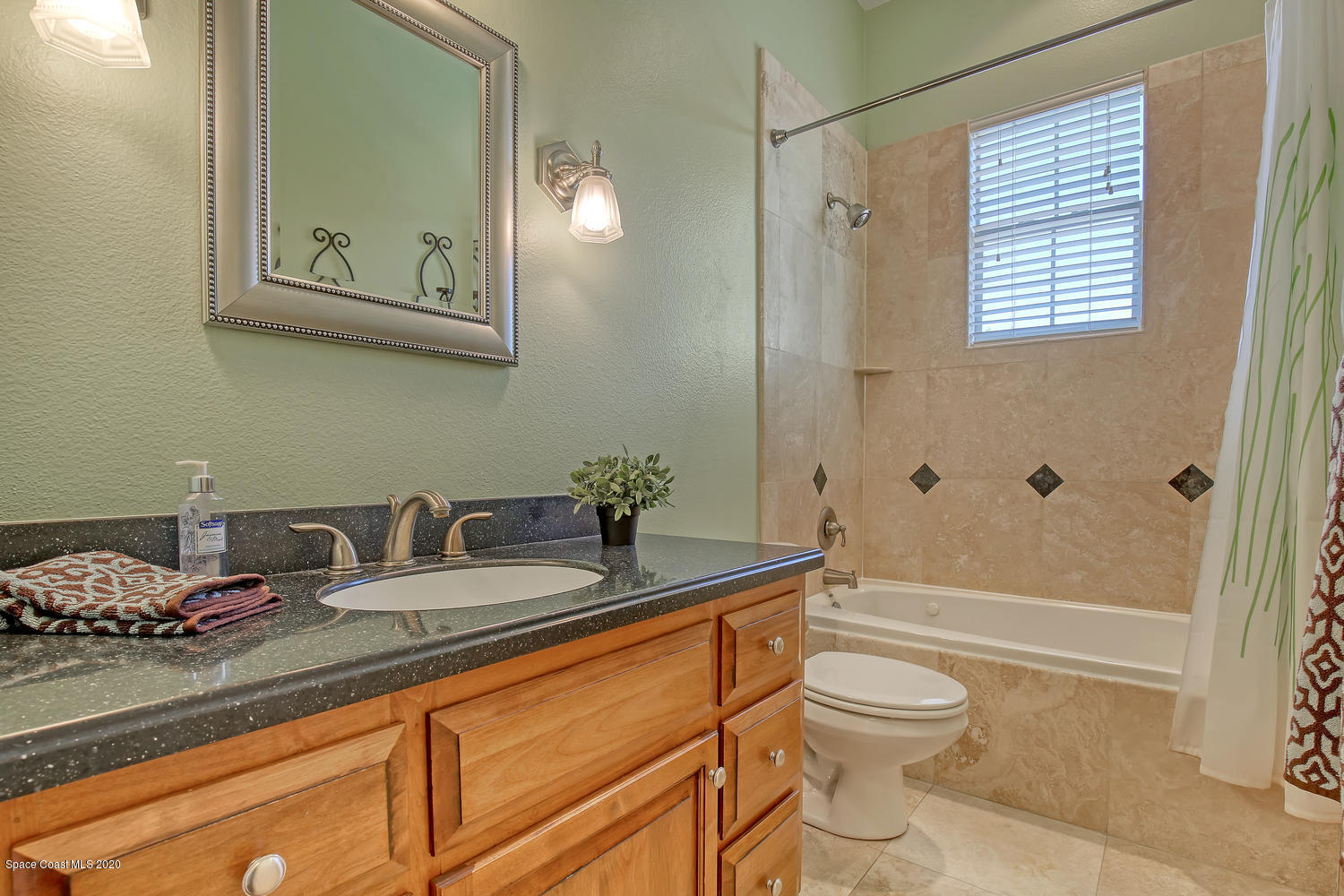 3960 Crooked Mile Road Merritt Island, FL 32952 - Photo 22 of 42 a bathroom with a granite countertop sink a toilet and shower