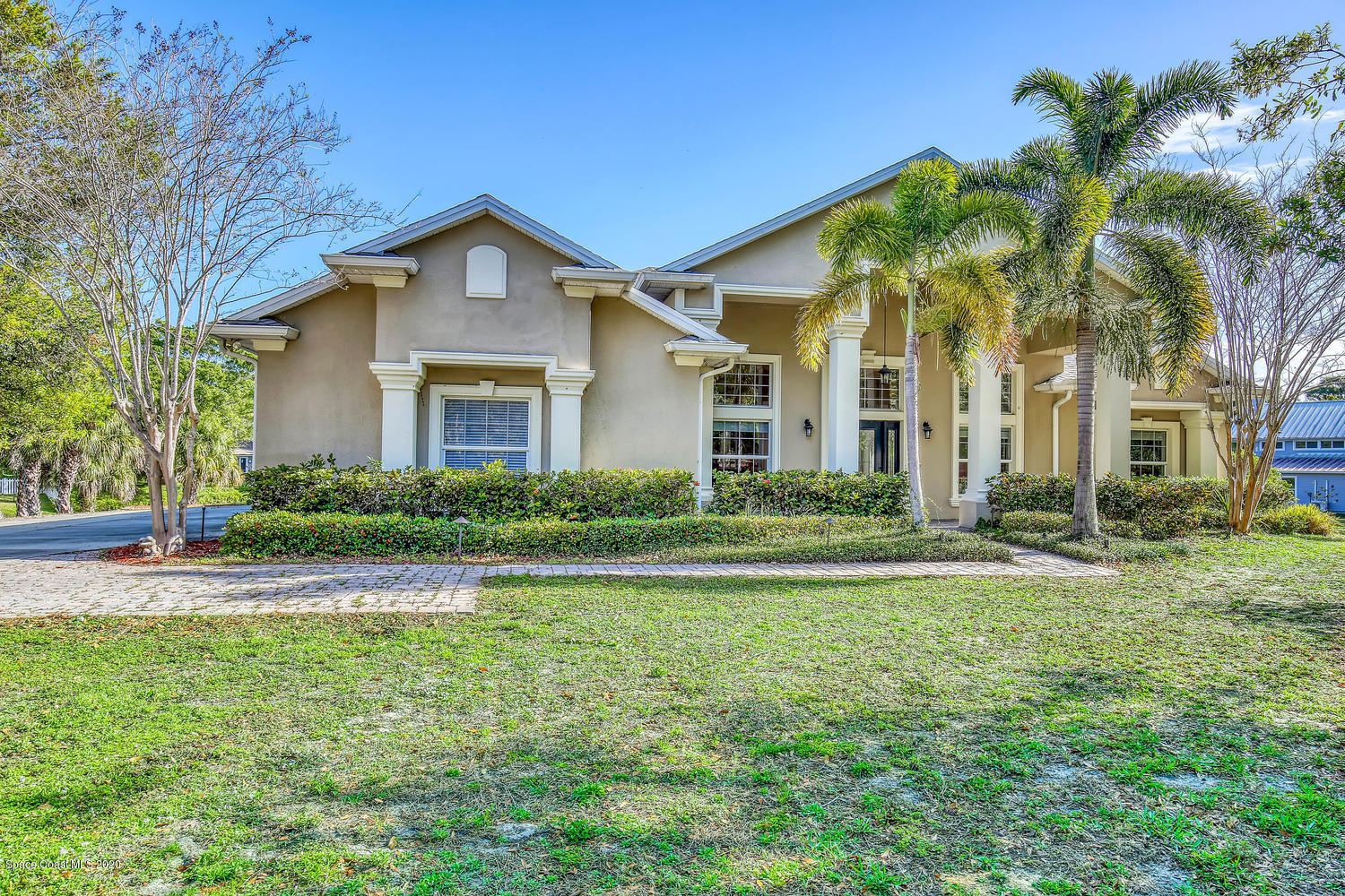 3960 Crooked Mile Road Merritt Island, FL 32952 - Photo 4 of 42 a view of a house with a yard and palm trees