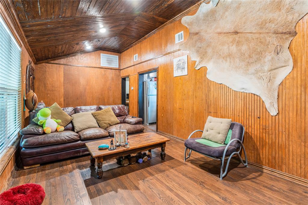548 Elston Drive Dallas, TX 75232 - Photo 2 of 18 Living area with wooden walls, high vaulted ceiling, wood finished floors, and wooden ceiling