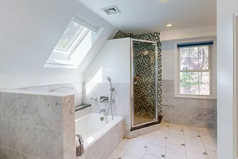 a bathroom with a bathtub a shower and a sink