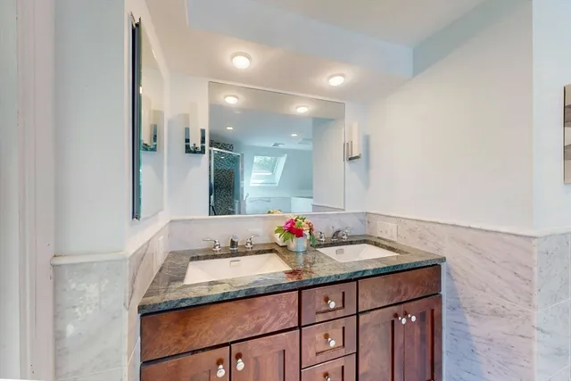 a bathroom with a granite countertop sink and a mirror