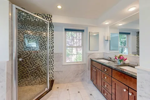 a bathroom with a granite countertop sink a shower and a mirror