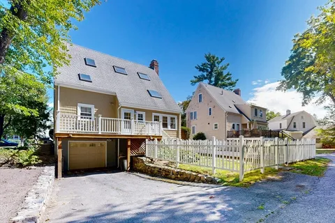 a front view of a house with a yard and potted plants