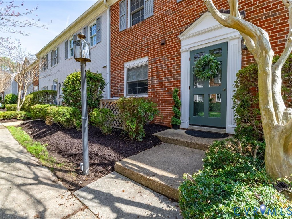 9107 Derbyshire Road, Unit J Henrico, VA 23229 - Photo 4 of 38 a view of a house with brick walls plants and flower plants