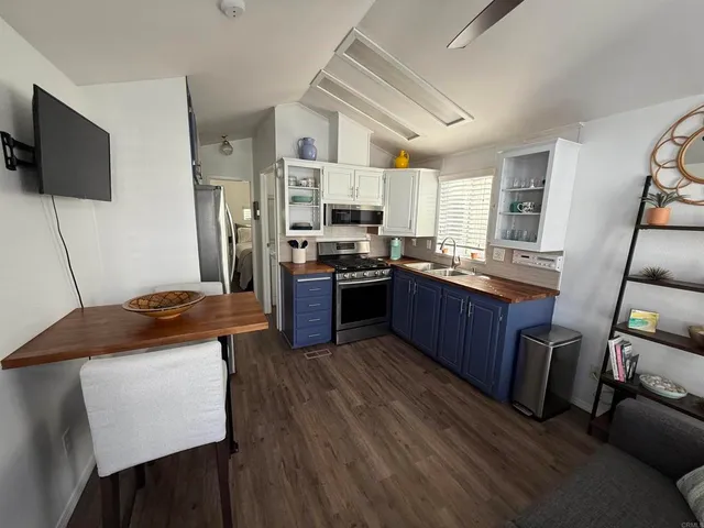 a kitchen with stainless steel appliances granite countertop a stove top oven a sink dishwasher microwave and refrigerator