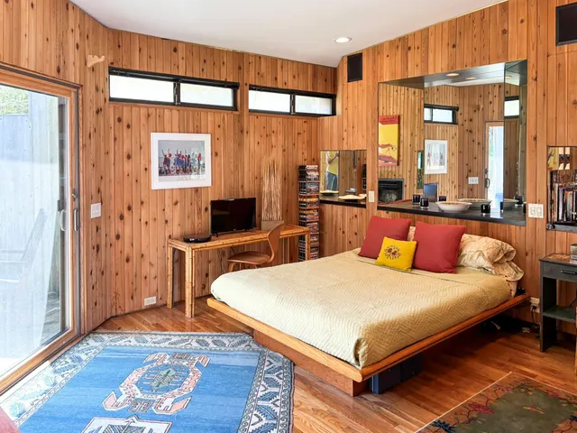 a bedroom with a bed and wooden floor
