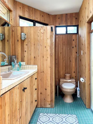 a bathroom with a sink a toilet and shower