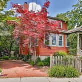 a front view of a house with a tree