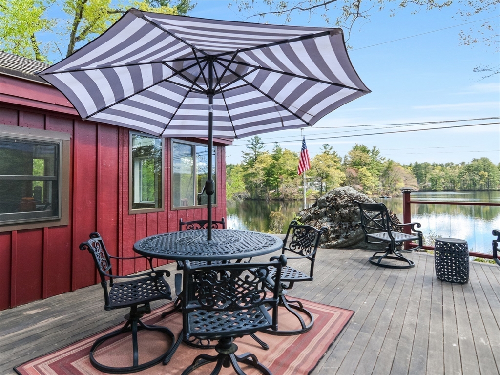 38 Cote Lane Sutton, MA 01590 - Photo 26 of 33 a patio with wooden floor a yard a table and chairs