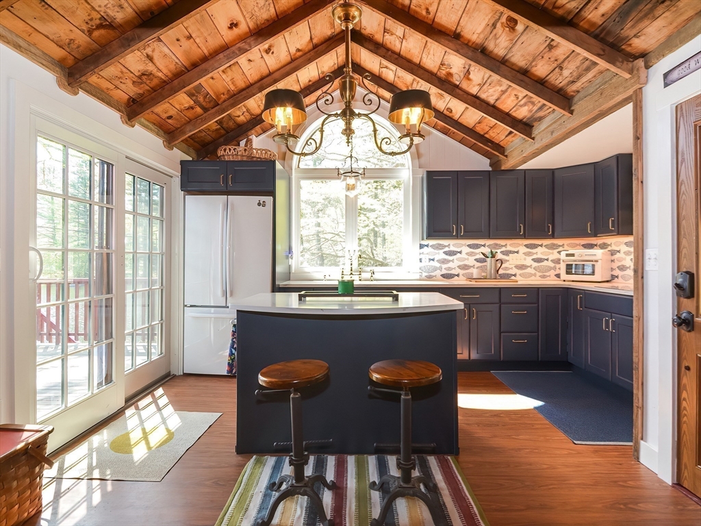 38 Cote Lane Sutton, MA 01590 - Photo 4 of 33 a kitchen with stainless steel appliances granite countertop a stove a refrigerator a sink a dining table and chairs with wooden floor