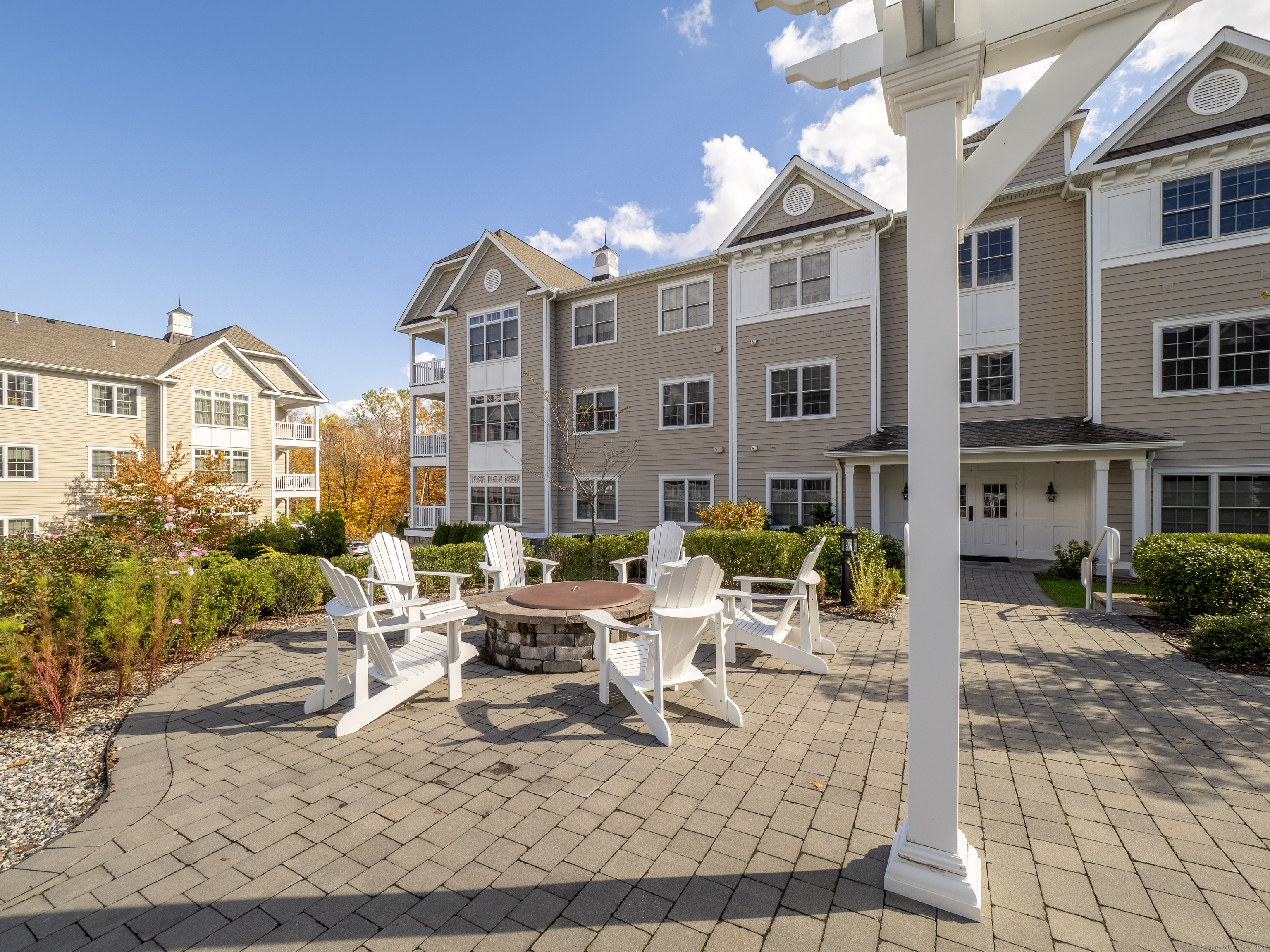 77 Sunset Lane, Unit 223 Ridgefield, CT 06877 - Photo 34 of 38 a view of a patio with couches table and chairs and potted plants