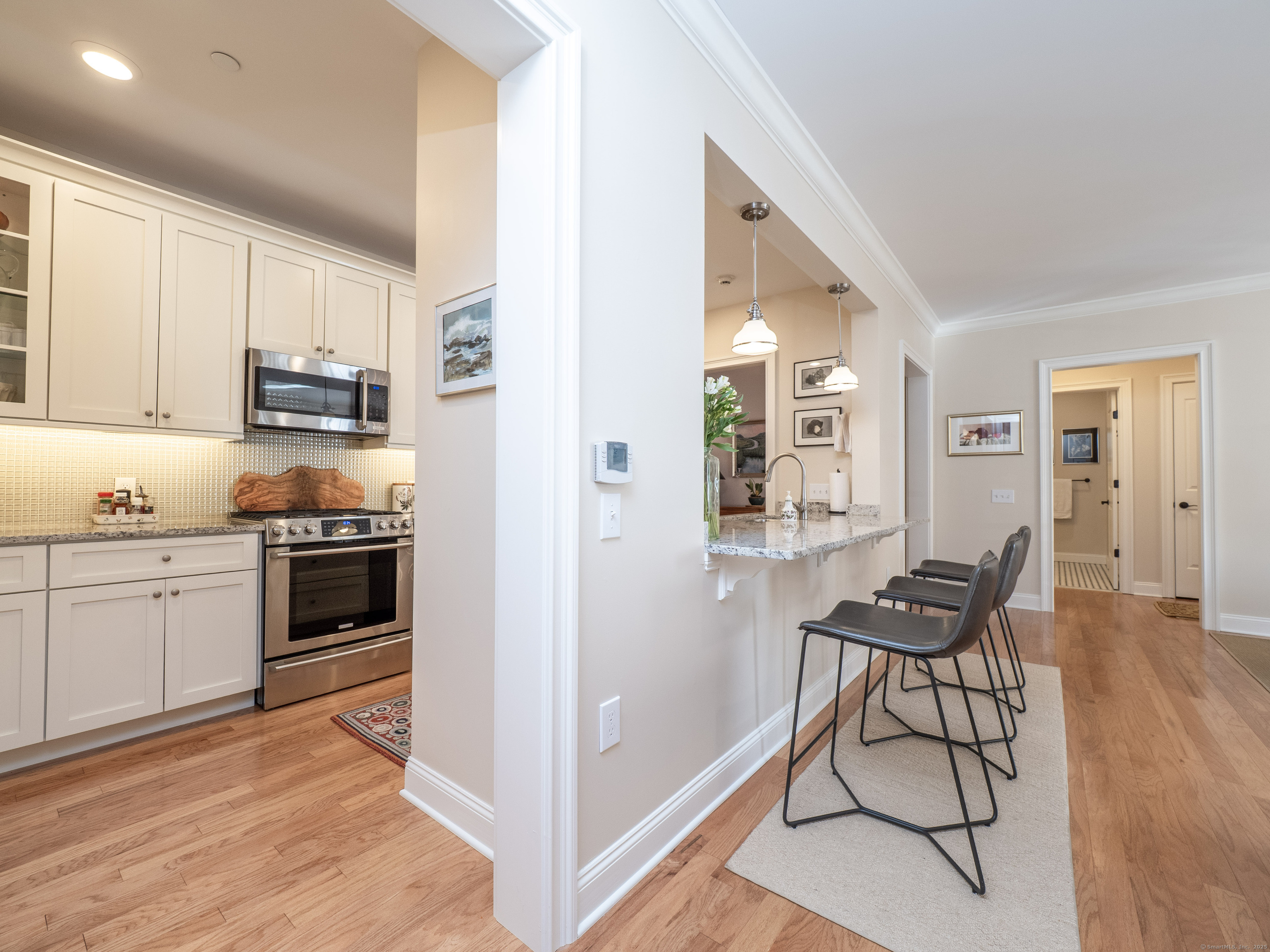 77 Sunset Lane, Unit 223 Ridgefield, CT 06877 - Photo 5 of 38 a kitchen with a refrigerator and white cabinets