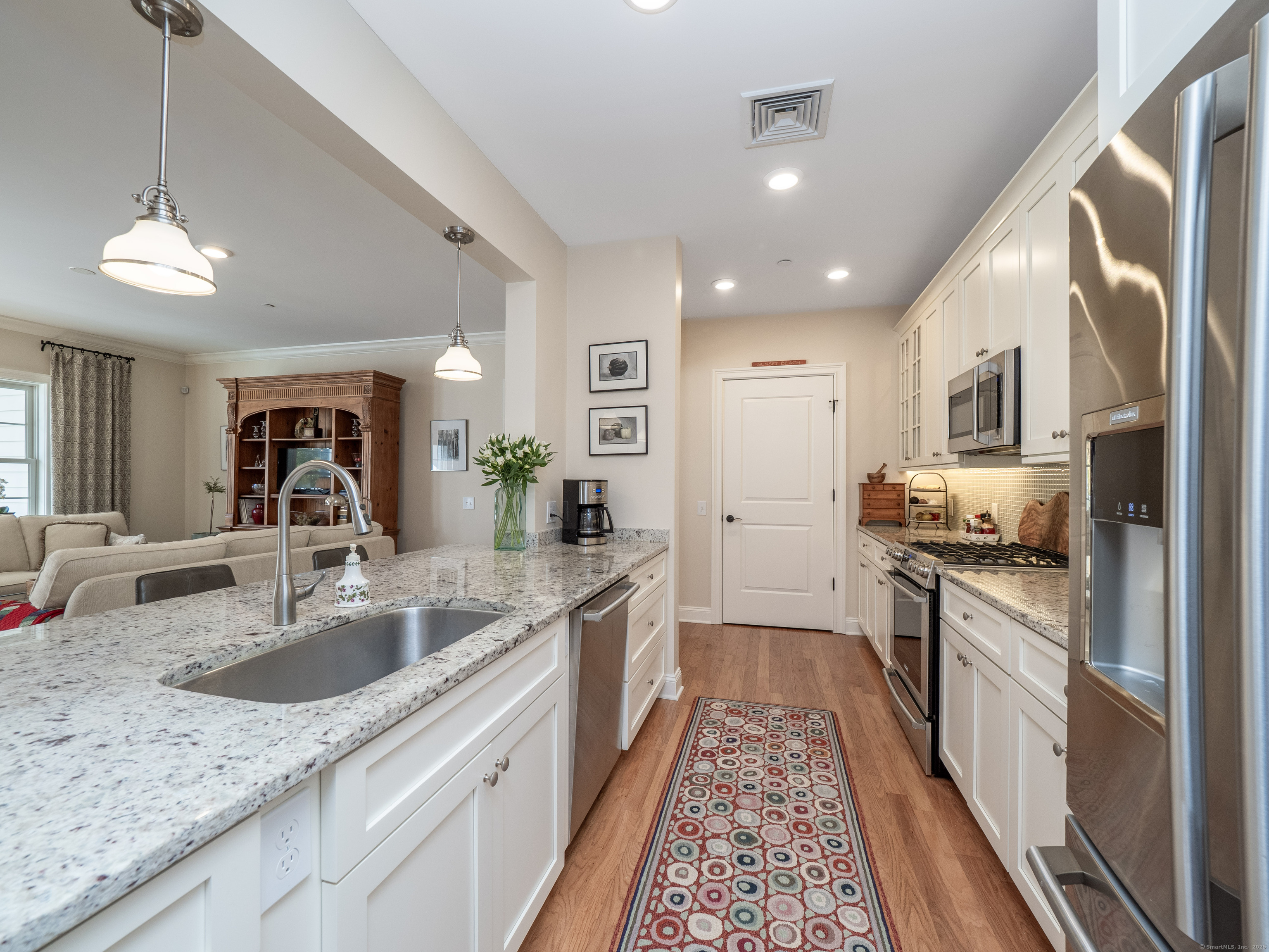 77 Sunset Lane, Unit 223 Ridgefield, CT 06877 - Photo 6 of 38 a large kitchen with stainless steel appliances granite countertop a sink and dishwasher a stove with wooden floor