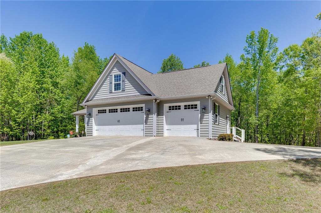 7660 Fern Lane Lula, GA 30554 - Photo 2 of 50 a front view of a house with a garden and yard