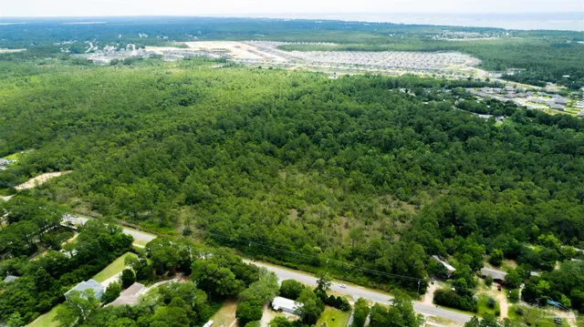 an aerial view of residential houses with outdoor space and trees