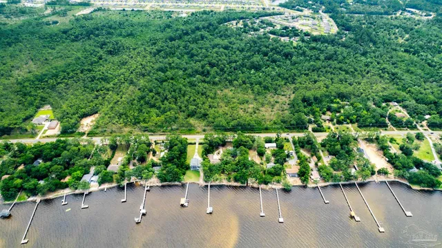 an aerial view of a house with a yard and greenery space