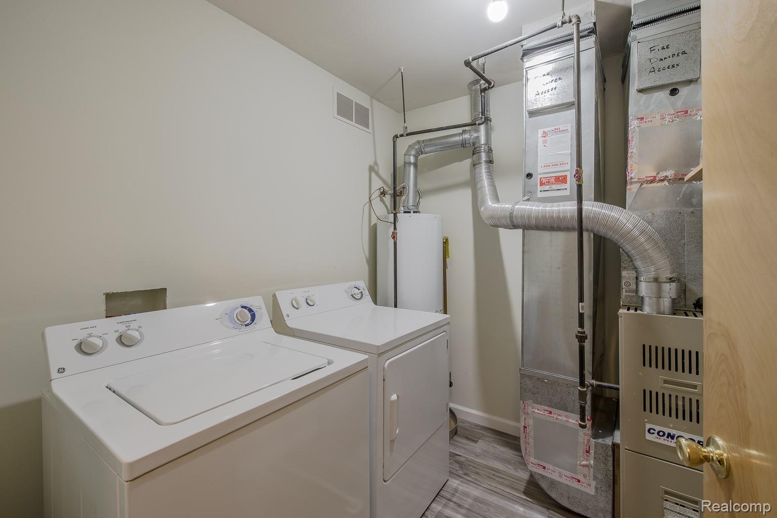 2154 Frazho Road Warren, MI 48091 - Photo 24 of 36 Utility area featuring a water heater, furnace, and wood-finish flooring