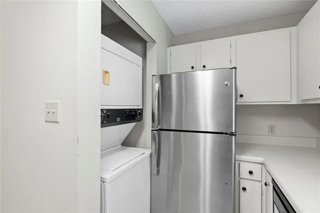 an empty room with windows and chandelier fan