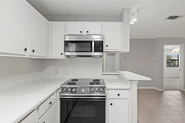 an empty room with windows and fireplace