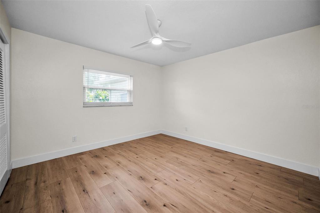 409 Barbara Lane Tampa, FL 33609 - Photo 19 of 51 an empty room with wooden floor and windows
